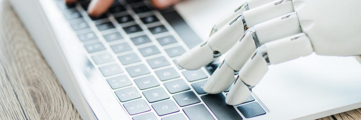 Ein Laptop, der von Roboterhänden bedient wird und Rechnungen digitalisiert.