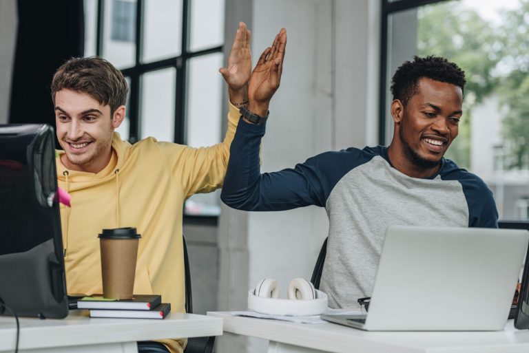 Twee mannen werken achter hun computer, waarbij het lijkt alsof ze gebruikmaken van Microsoft Copilot.