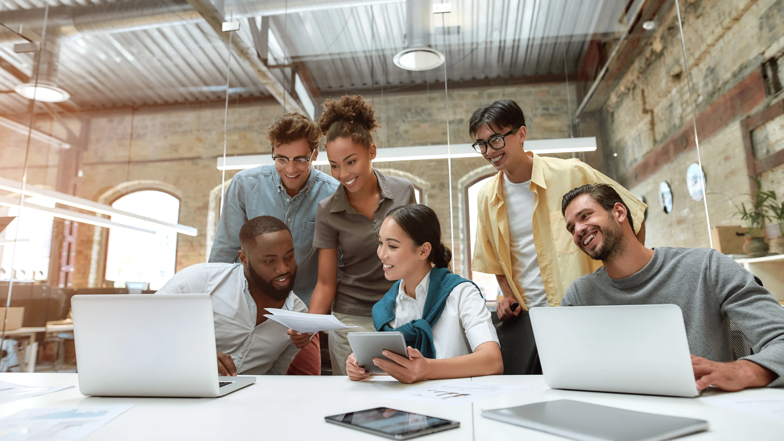 A woman and her colleagues look at some papers they are going to process in their document portal.