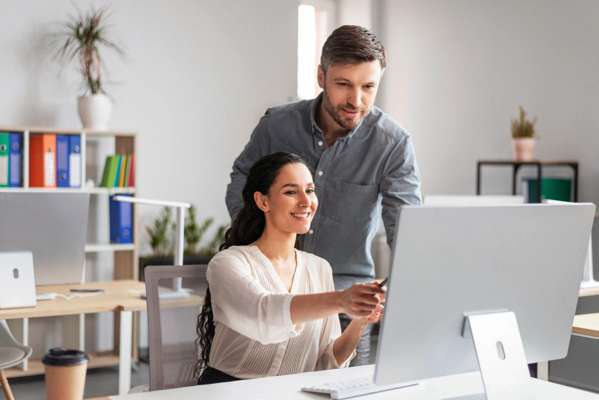 Husband and wife look together at the computer on which they do online accounting.