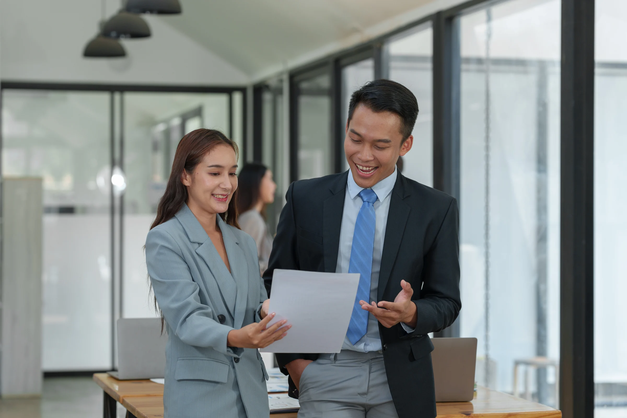 A man and a woman laughingly look at a paper to assess a company's solvency.