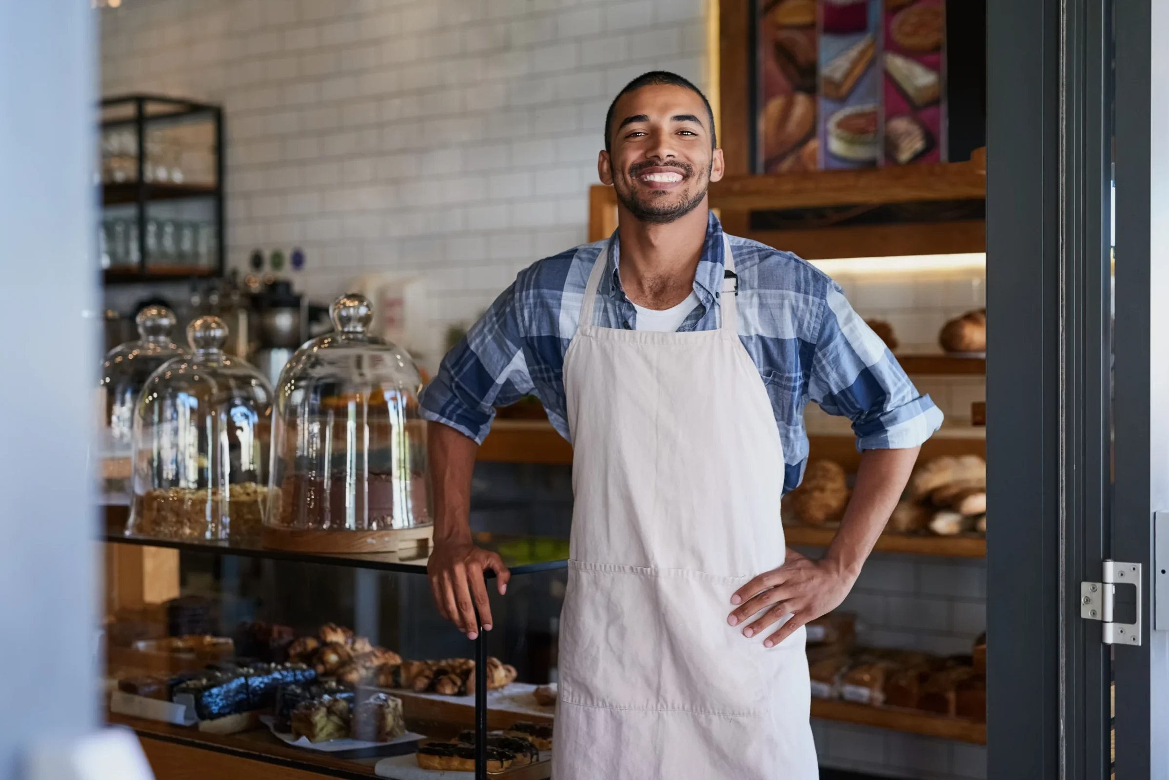 A man looks smiling into the camera while working a 1 fte.