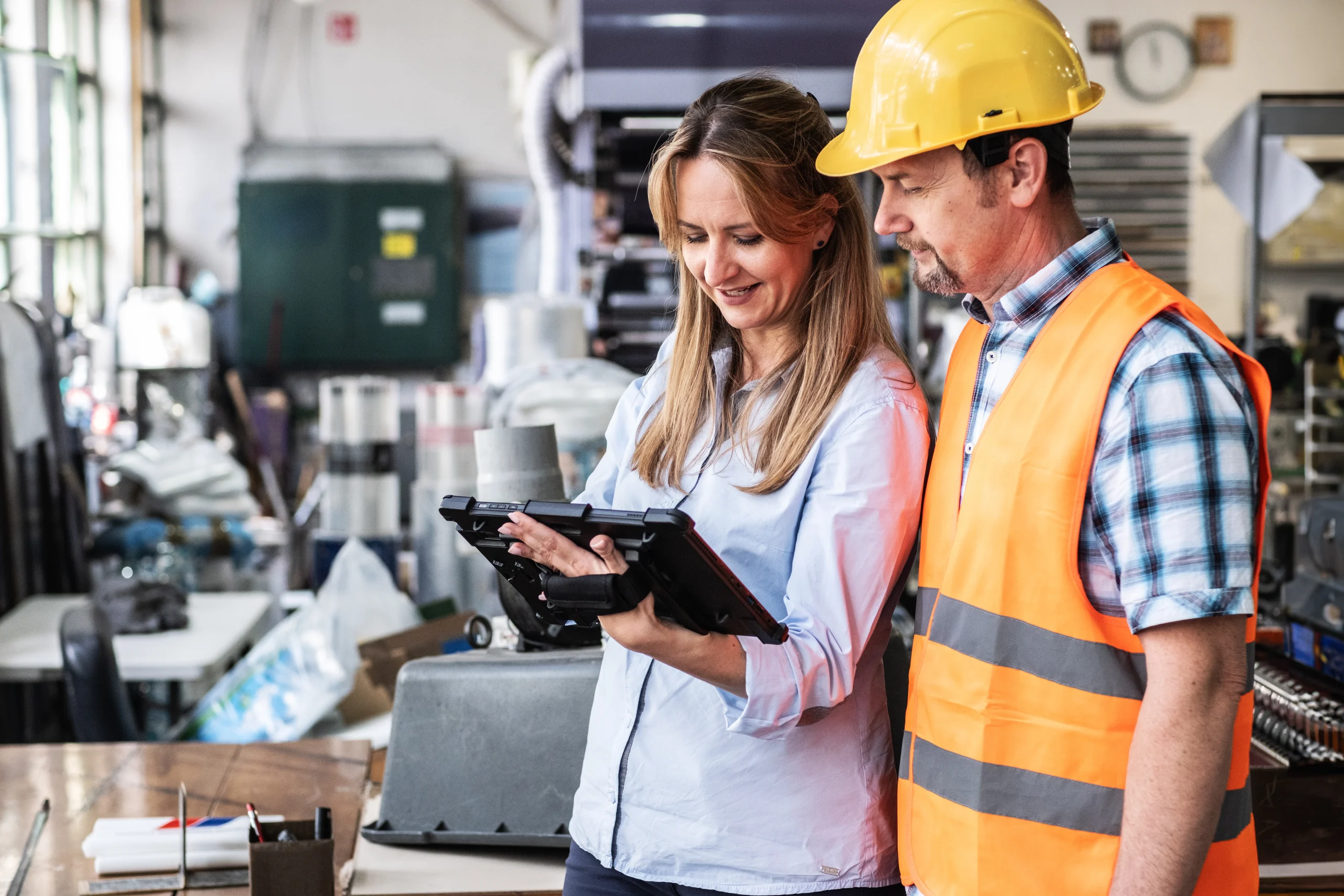 A man and a woman look at a tablet together as they look up and check a VAT Number.