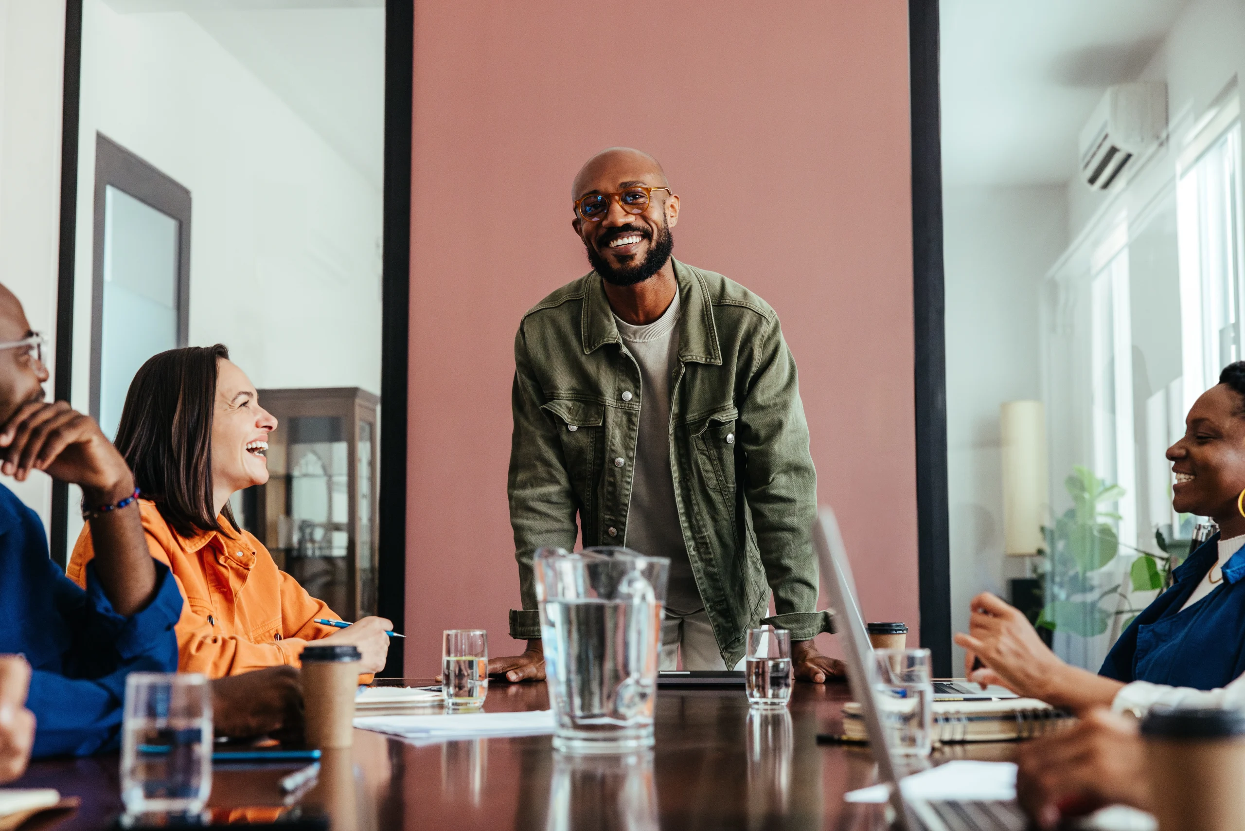 A man stands smiling at a table because he could apply for a VAT number in a very easy way.