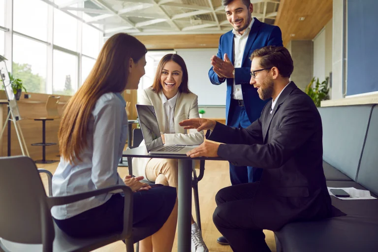 Groep collega's lijkt samen te werken achter een computer met de software van Sharepoint.