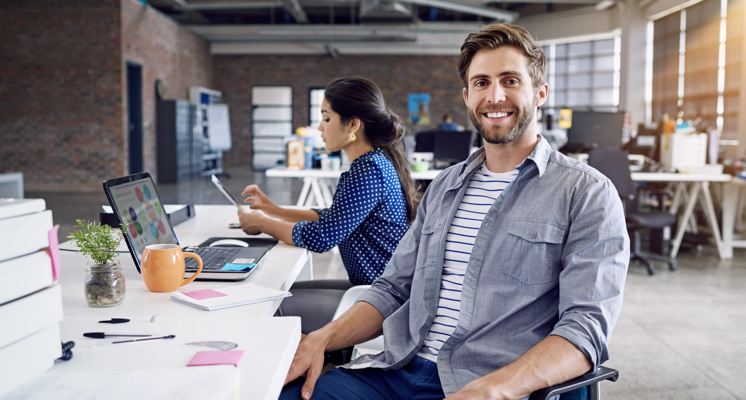 A man looks smiling into the camera as he works on Current Ratio.