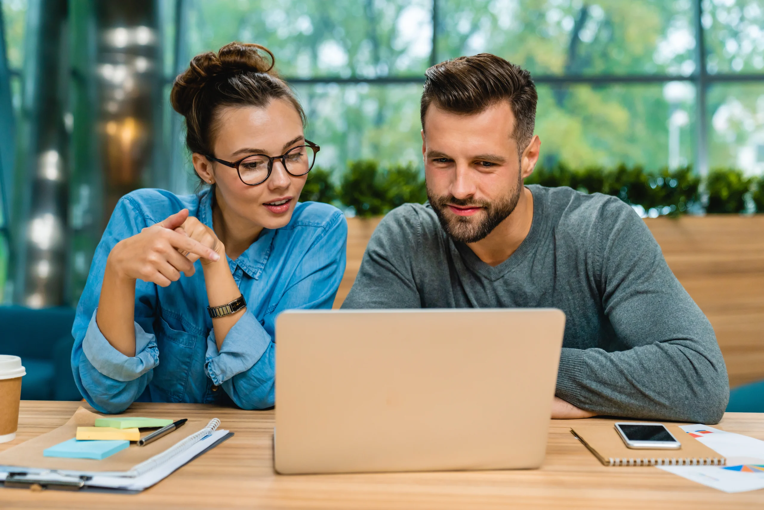 Een man en een vrouw werken samen aan een laptop om hun documenten te digitaliseren.