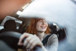 Een vrouw rijdt in een auto en is helemaal op de hoogte van Reiskostenvergoeding 2024.