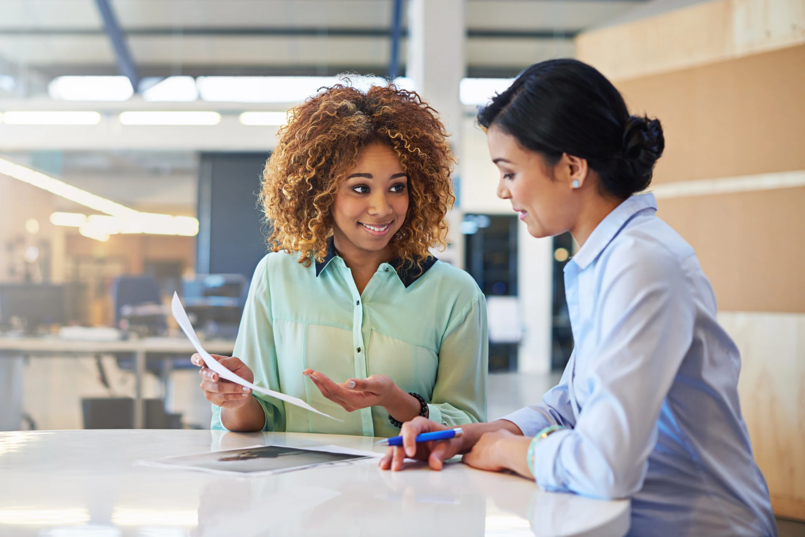 Two women discuss a Profit and Loss statement.