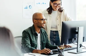 Een man en een vrouw werken samen op een computer en bespreken de Quick Ratio van een bedrijf.