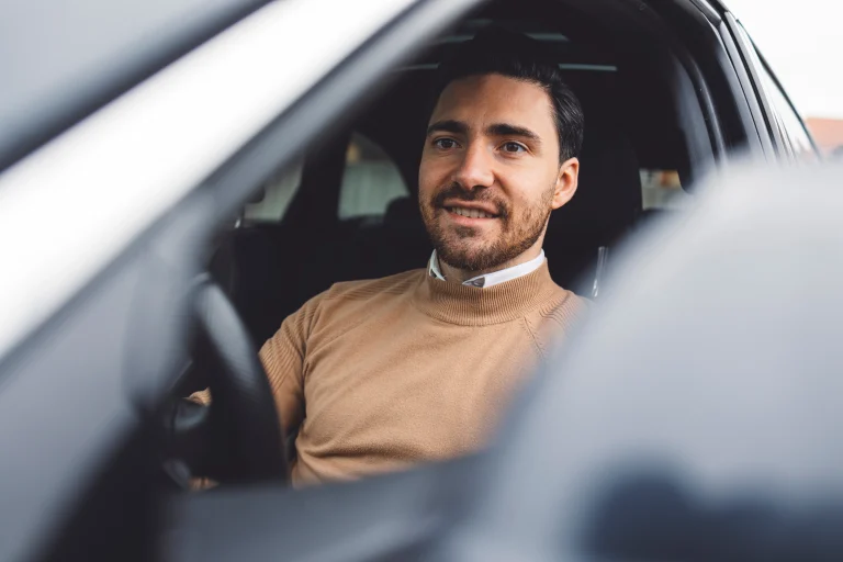 Een man rijdt in de auto, terwijl hij gebruikmaakt van de WKR en de wijzigingen in 2025.