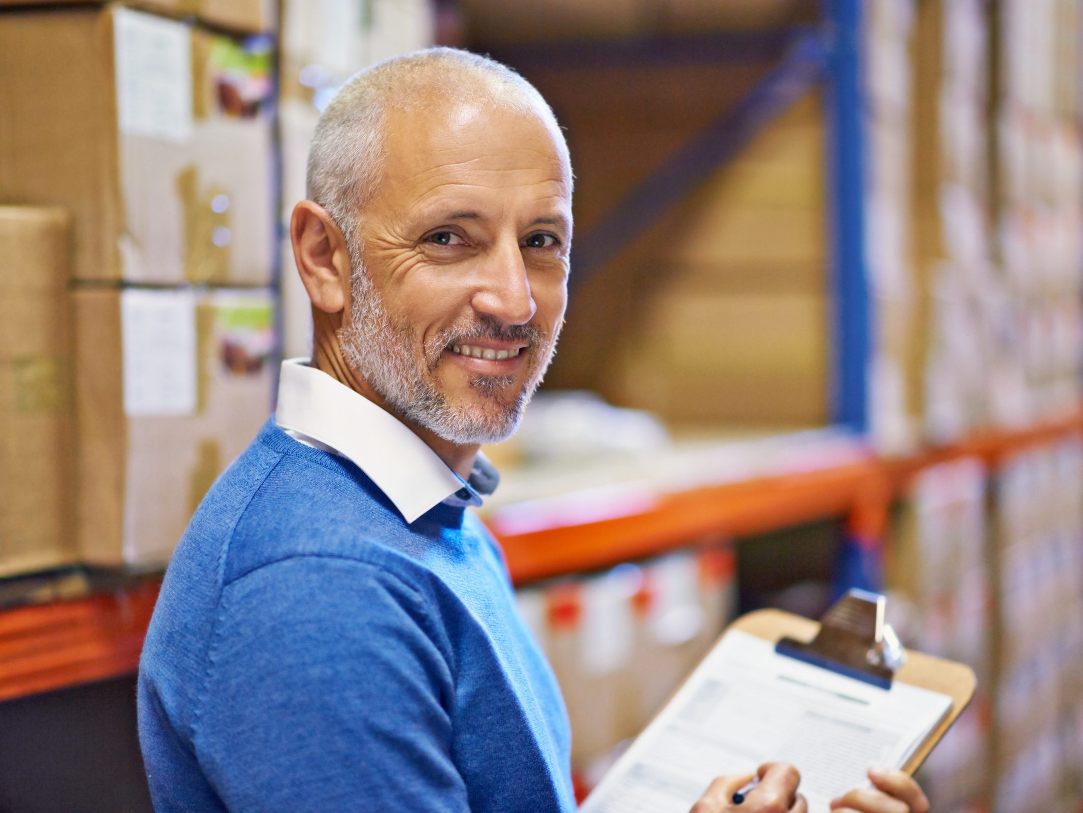 A man is smiling as he checks a purchase order.