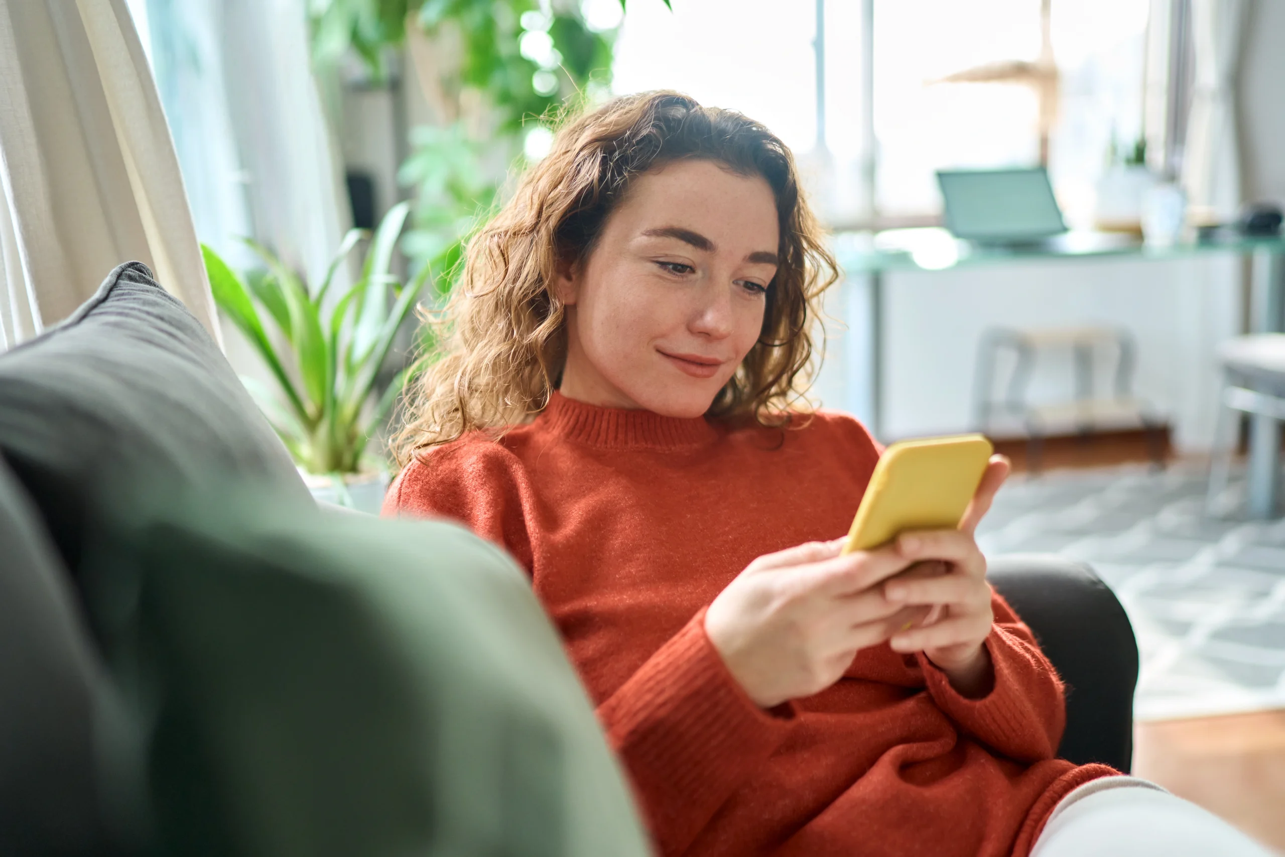 Une femme s'assoit sur son téléphone et utilise l'application TriFact365 sans problème grâce à ces conseils.