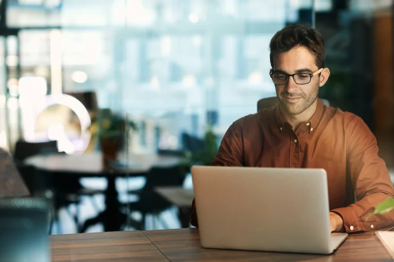 Een man zit achter een laptop een E-invoice maken: eenvoudiger, sneller en slimmer factureren