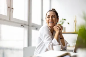 Een vrouw lacht om Inzicht in financiën is het nieuwe goud
