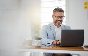 Een man lacht om de kracht van de beginbalans: jouw financiële startpunt uitgelegd