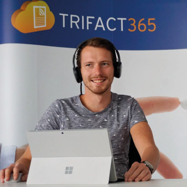 Employee of TriFact365 behind his laptop.